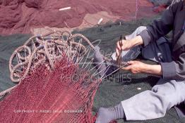 Image du Maroc Professionnelle de  Un ouvrier s'active à réparer les filets de pêche sur un des quais au port d'Agadir, ville située au sud du Maroc, Vendredi 23 Août 2002. (Photo / Abdeljalil Bounhar)

 